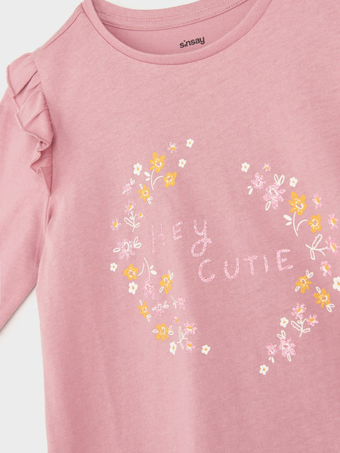 Pink long-sleeve shirt with floral designs and 'Hey Cutie' text on a white background
