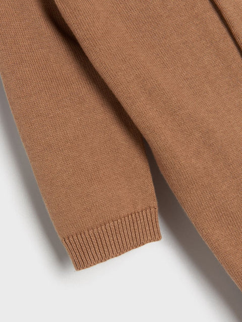 Close-up of a brown sweater sleeve on a light gray background