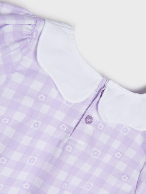 Close-up of a lavender checkered dress with a white collar on a light background