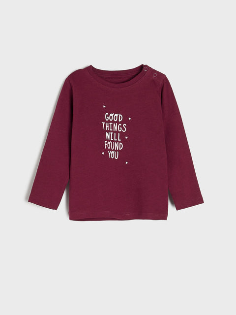 Maroon long-sleeve shirt with text on a light gray background