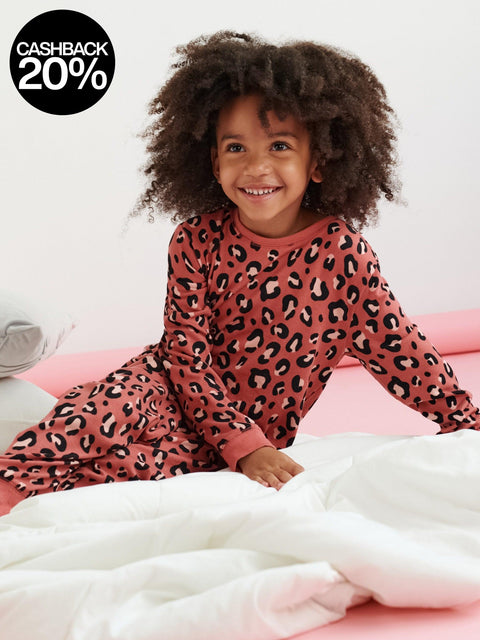 Child wearing pink leopard print pajamas sitting on a bed with a cashback 20% offer in the corner.