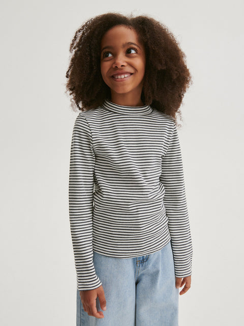 Child wearing a striped long-sleeve shirt and light blue jeans on a white background