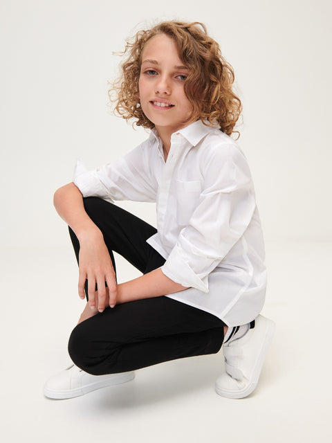 Person wearing a white shirt and black pants on a white background