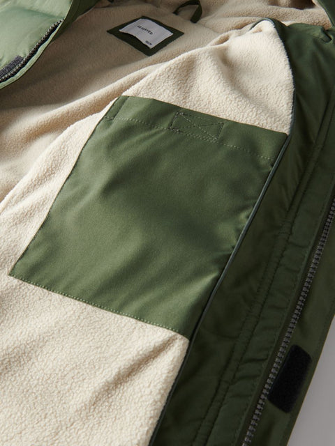 Close-up of a jacket with green and beige color block design.