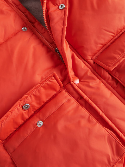 Close-up of a red puffer jacket with zippers and buttons.