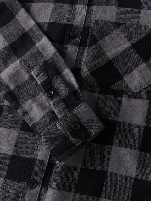 Close-up of a black and gray plaid shirt with buttons.