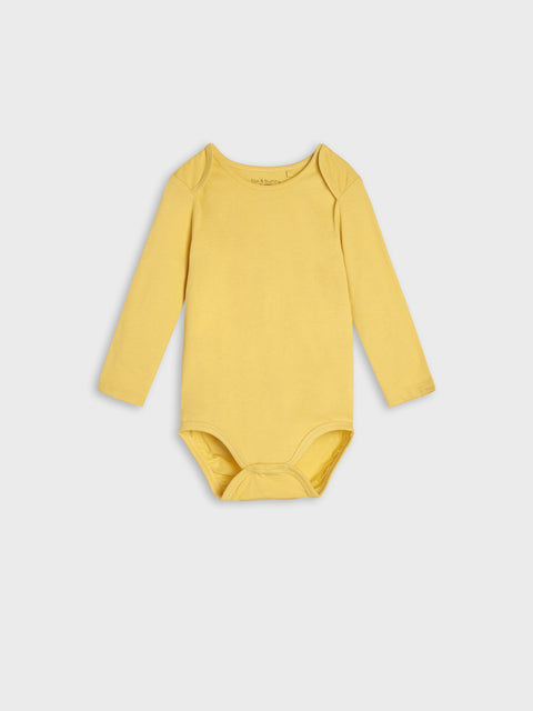 Yellow baby bodysuit on a light gray background