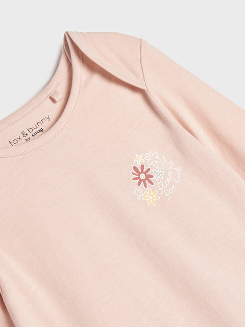 Pink garment with floral design and 'fox & bunny' branding on a light background
