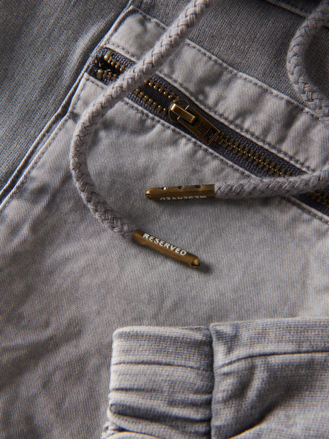 Close-up of a gray jacket with a zipper and 'RESERVED' tag.