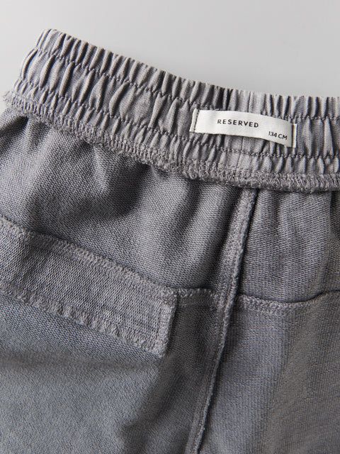 Gray pants with a 'RESERVED' label on the waistband against a light gray background
