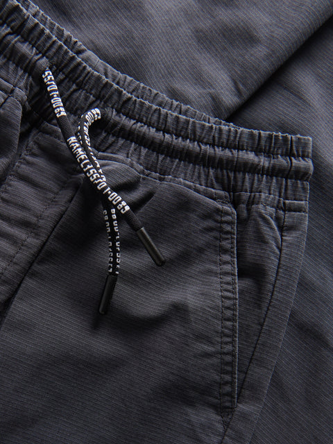 Close-up of dark gray pants with a drawstring, focusing on the waistband.