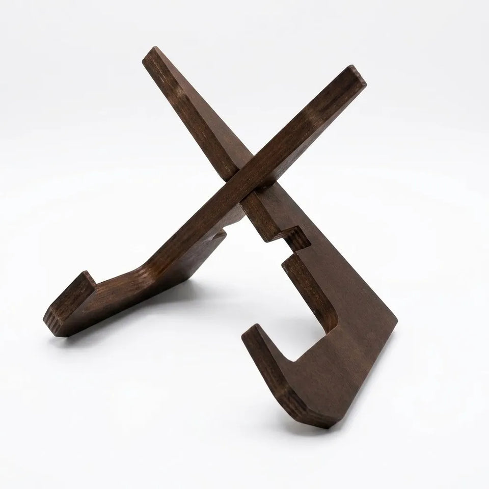 A dark brown wooden stand with a geometric, crossed design, photographed on a seamless white background.