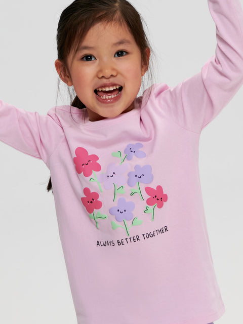 Child wearing a pink long-sleeve shirt with floral designs and text on a white background