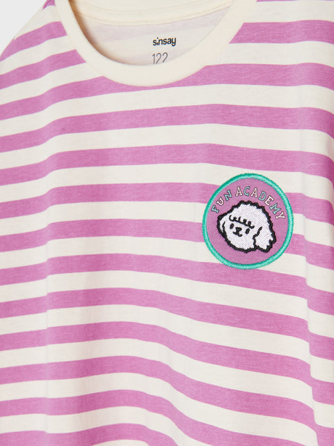 Pink and white striped shirt with a logo on a pink background