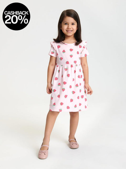 Young girl wearing a pink dress with red heart patterns on a white background