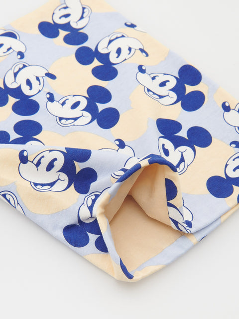 Folded fabric with blue and white Mickey Mouse pattern on a beige background