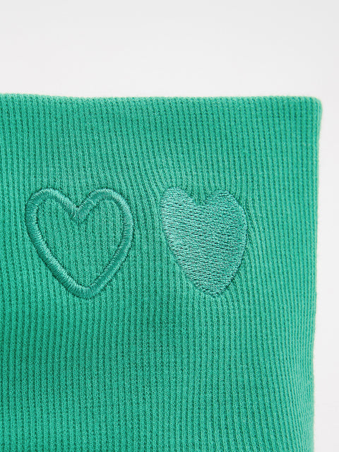 Green neck gaiter with heart design on a light gray background