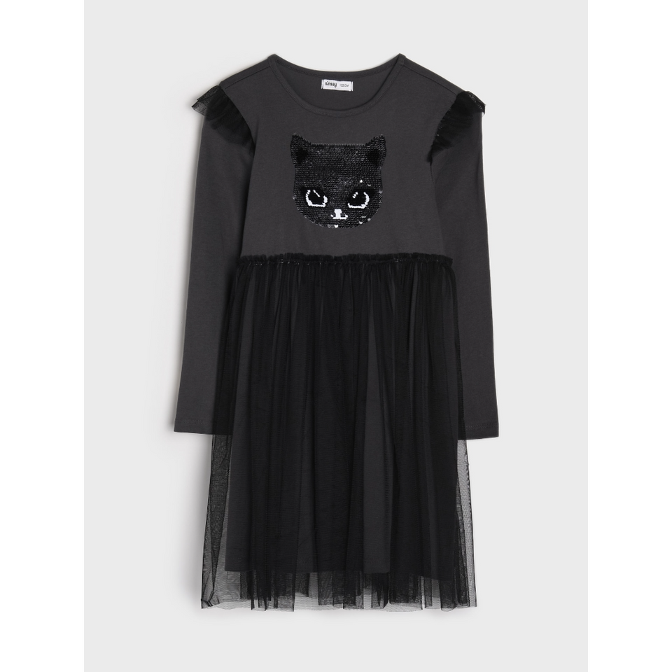 A black long-sleeve dress for girls featuring a sequined black cat face on the chest, ruffled shoulder details, and a layered black tulle skirt, shown against a light gray background.