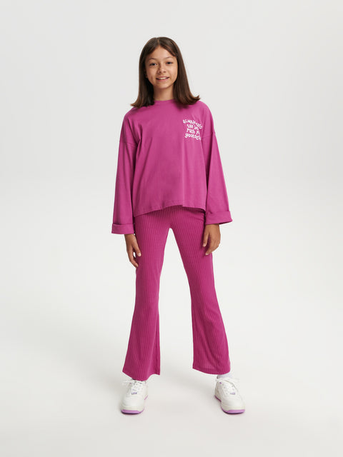 Person wearing a pink outfit with text on a white background