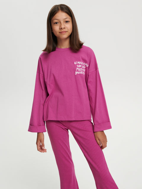 Child wearing a pink outfit with text on a white background