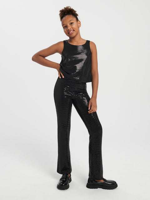 Person wearing a black sequin outfit on a white background