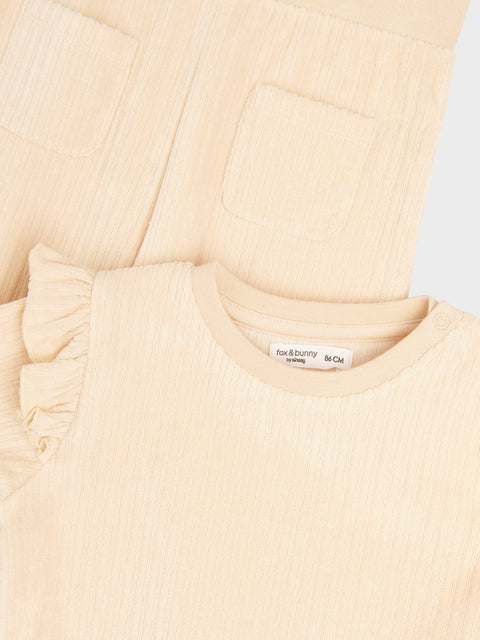 Close-up of a beige textured fabric with a brand label on a light gray background