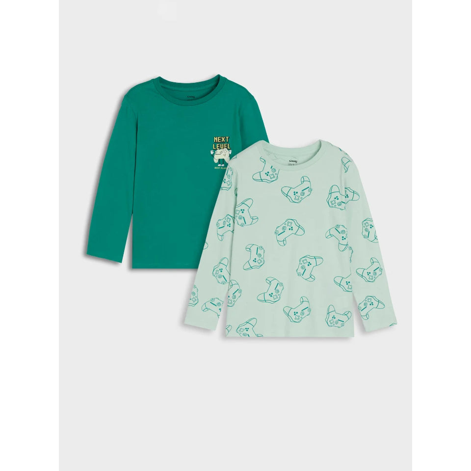 Two long-sleeve children's tops laid flat on a light gray background. The top on the left is teal green with a small chest graphic reading 'NEXT TIME'.