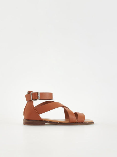 Brown sandal with a single strap on a white background