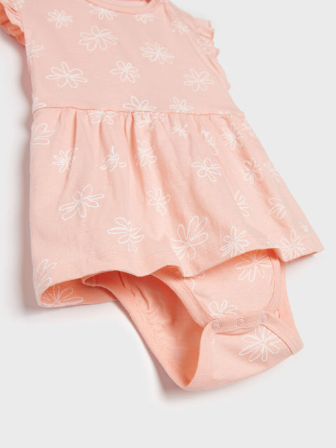Pink dress with white floral patterns on a light gray background