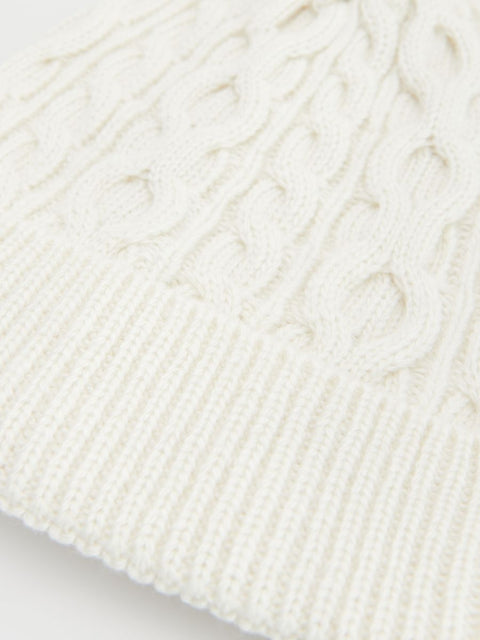 Close-up of a textured white fabric with cable knit pattern