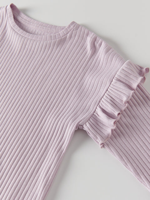 Pink ribbed sweater with ruffled sleeves on a light gray background