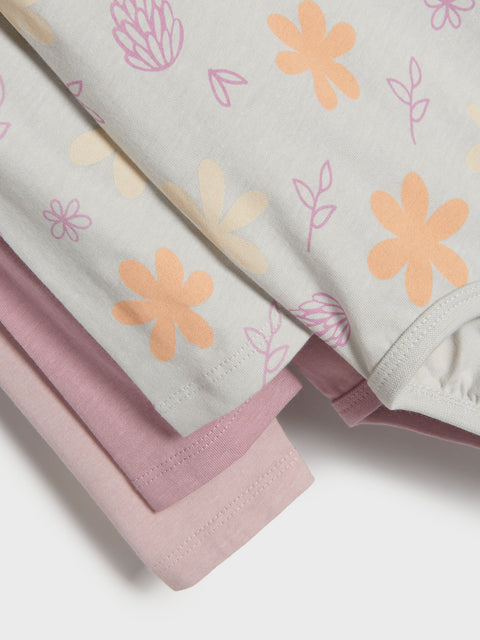 Stack of baby blankets with floral patterns on a white background