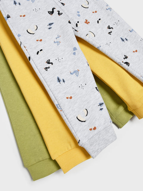 Stack of colorful baby pants with patterns on a white background