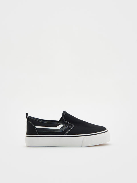 Black slip-on sneaker with white sole on a light gray background
