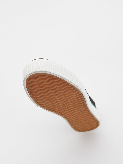 Close-up of a shoe sole with brown tread pattern on a white background