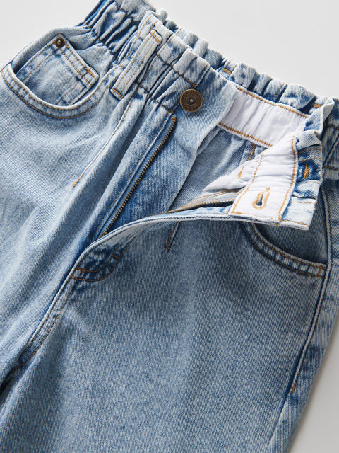 Close-up of light blue denim jeans with a focus on the waistband and stitching.