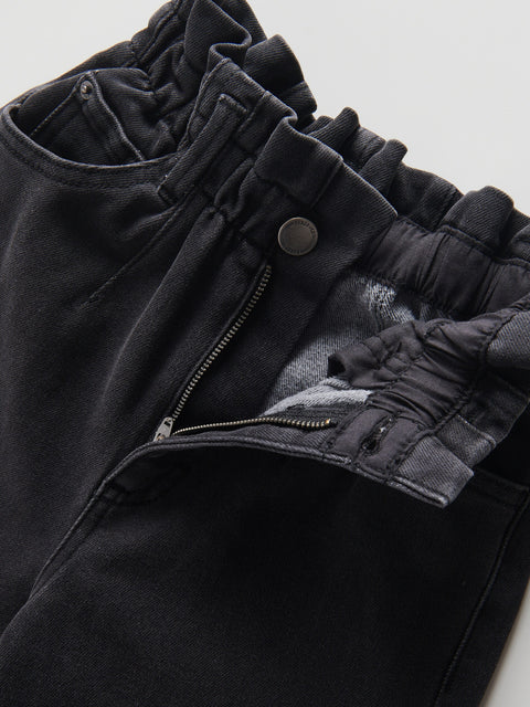 Close-up of a black jacket with zippers and buttons on a light gray background