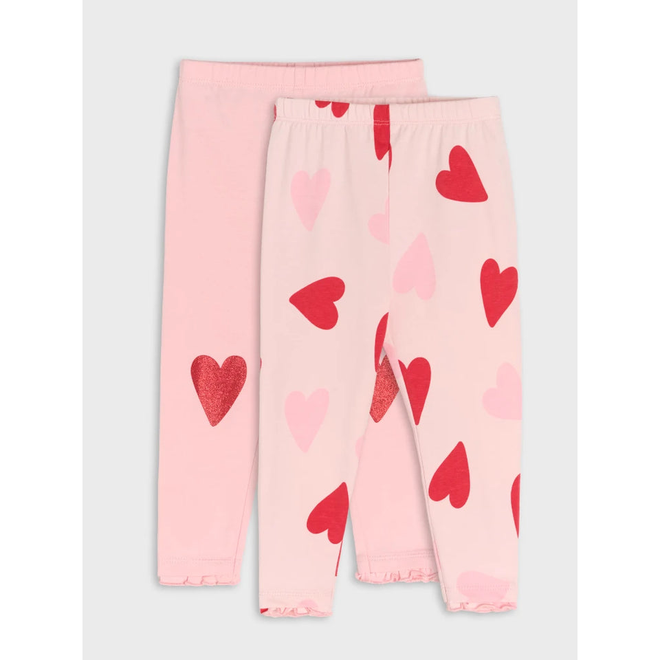 A pair of children's pink leggings with a heart pattern, featuring one solid light pink leg and one patterned leg with red and light pink hearts, displayed on a light gray background.