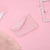 A light pink ribbed knit headband with a soft fleece lining, styled on a solid pink background with decorative props.