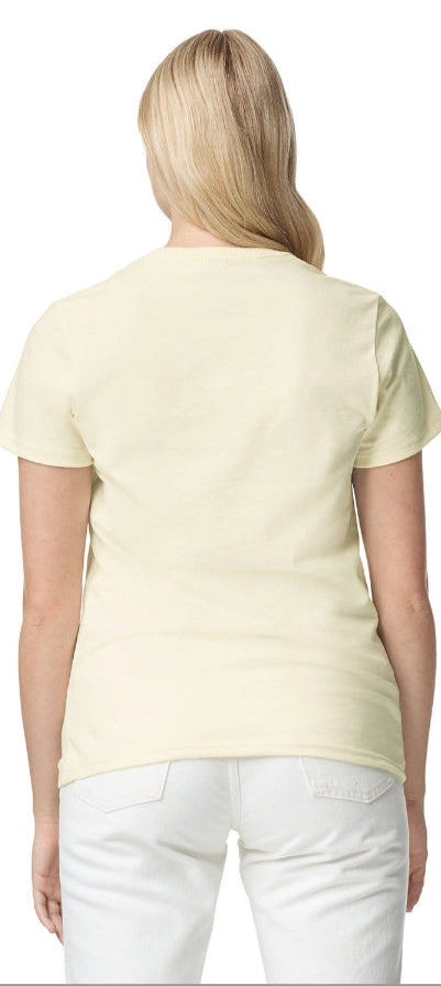 Woman wearing a light yellow t-shirt and white pants on a plain background