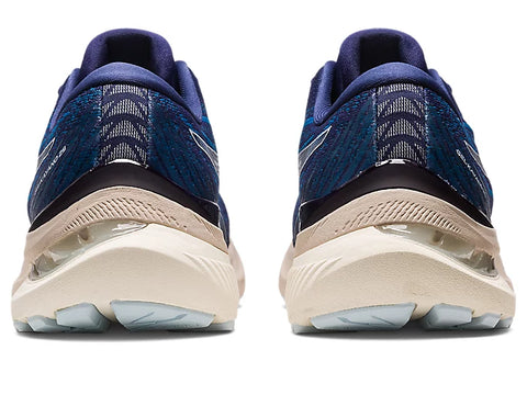 Pair of blue running shoes with beige soles on a white background