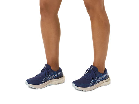 Blue running shoes worn by a person on a white background