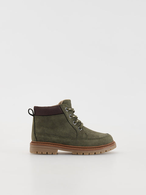 Green suede boot with brown accents on a light gray background