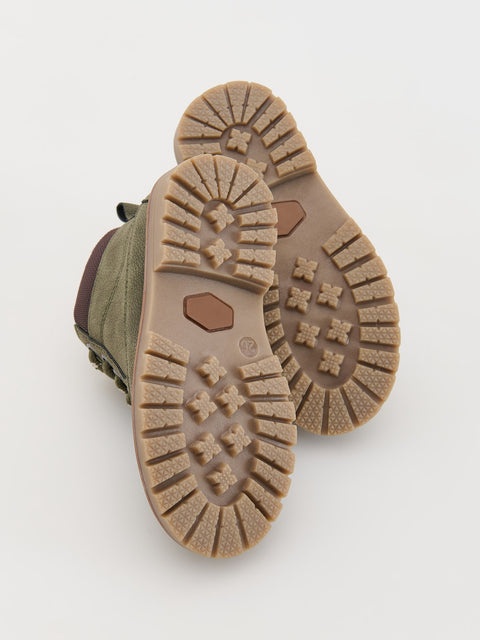 Close-up of a pair of boots with tread pattern on a light gray background
