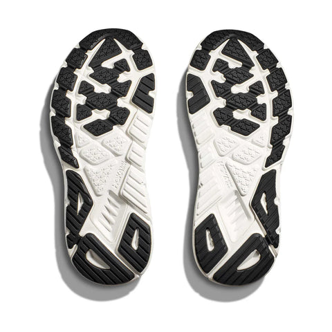 Close-up of a pair of white running shoes with black sole pattern on a white background