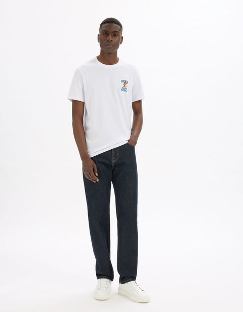 Man wearing a white t-shirt with a colorful graphic and dark jeans on a white background