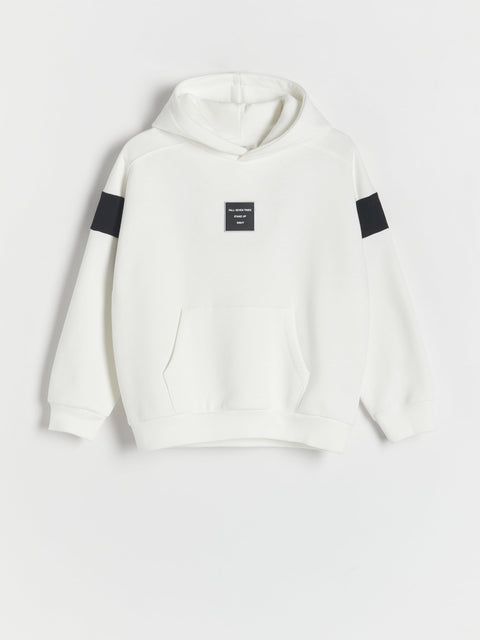 White hoodie with black patches on a light gray background