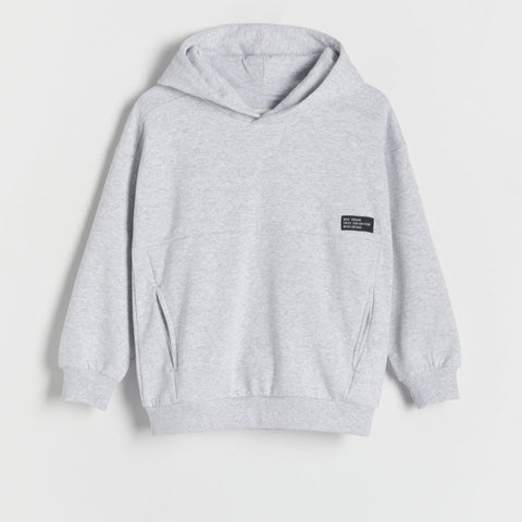 Gray hoodie with a small black label on a light gray background