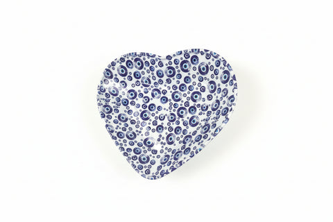 Hand holding a blue and white patterned object against a neutral background