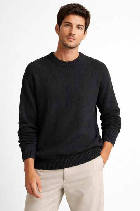 Man wearing a black sweater and beige pants on a white background